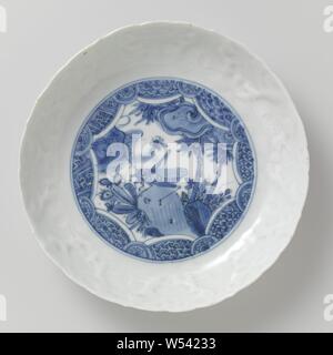 Piatto, piattino - piatto con un grasshopper su una roccia, porcellana piatto con un bordo dentellato, dipinta in underglaze blu. Sul ripiano di una stella cartiglio con una cavalletta su una roccia con piante fiorite e bambù. Il cartiglio igienico il lavoro e la metà dei fiori. Sul bordo interno di una band con vitigni di fiori e melograni in rilievo. La cottura della sabbia sui piedi anello. Porcellana crepata in blu e bianco, insetti: erba-tramoggia, anonimo, Cina, c. 1580 - c. 1620, Ming-dinastia (1368-1644) / Wanli-periodo (1573-1619), porcellana (materiale), smalto, cobalto (minerali), di vetrificazione, h 3,8 cm d 20,1 cm d 12,9 Foto Stock