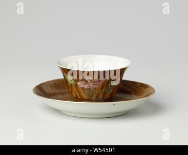 Tazza e piattino con peonia e antichità su una tavola di legno colorato di massa, tazza di porcellana con piattino con la diffusione della parete, coperto con un rosso-marrone di smalto e dipinta su smalto in rosso, rosa, verde, giallo, la melanzana e il nero. Il piatto è coperto con un marrone imitazione di legno sulla parte anteriore, una peonia ramo con due pezzi di antiquariato (libri, ruyi-scettro) salvati qui, disadorno all'esterno. Cup con lo stesso decor solo con l'imitazione di legno all'esterno e bianco all'interno con una pesca sul fondo. Famille rose., anonimo, Cina, c. 1725 - c. 1749, Qing-dinastia (1644-1912) / Yongzheng-periodo (1723-1735 Foto Stock