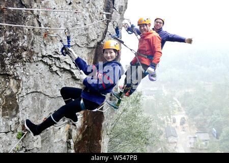 Il 69-anno-vecchio a doppio amputato scalatore cinese Xia Boyu tenta scalata su roccia a una scogliera montagna nella città di Taizhou, est della Cina di provincia dello Zhejiang, 14 Januar Foto Stock