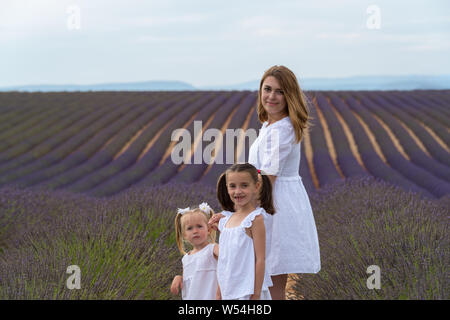 Valensole, Francia. Madre con le figlie nel campo di lavanda Foto Stock