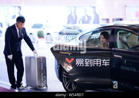 --FILE--un cliente scende da un veicolo con il logo di autonoleggio service provider Yongche Yidao presso un hotel a Pechino, in Cina, il 26 dicembre 2018. A- Foto Stock