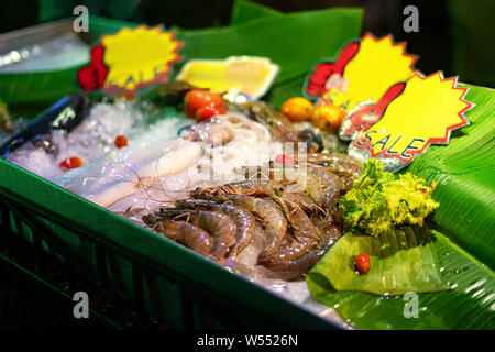 Pesce fresco, le seppie calamari e gamberetti per la vendita ad un pesce cafe in Thailandia di notte. Frutti di mare su ghiaccio sul contatore . della salute alimentare. Foto Stock
