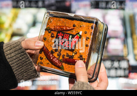 Un cliente negozi per una torta con la forma del piccante chafing dish condimento di hotpot nella città di Chengdu, a sud-ovest della Cina di provincia di Sichuan, 3 feb. Foto Stock