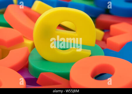 Giallo lettera "e" sulla pila di plastica colorata lettere e numeri Foto Stock