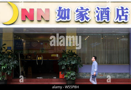 --FILE--A passeggiate a piedi passato un ramo di Homeinns o Home Inn Hotel nella città di Xiamen, a sud-est della Cina di provincia del Fujian, 19 aprile 2018. Il mento Foto Stock