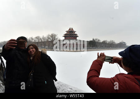 Gli appassionati di fotografia scattare foto della torretta presso il Museo del Palazzo, conosciuta anche come la Città Proibita, nella neve a Pechino in Cina, 14 febbraio Foto Stock