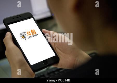 --FILE--un netizen utilizza la mobile app del gioco cinese video streaming platform Douyu, o 'lotta contro la pesca', sul suo smartphone nella città di Guangzhou, sud C Foto Stock