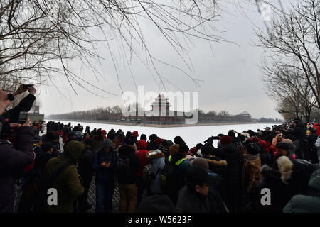 Gli appassionati di fotografia scattare foto della torretta presso il Museo del Palazzo, conosciuta anche come la Città Proibita, nella neve a Pechino in Cina, 14 febbraio Foto Stock