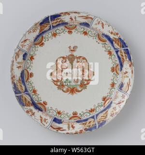 Piastra di faience con stemma Van Beuningen - Van Leeuwen, piastra di faience, in colori Imari con al centro l'alleanza stemma di Jan van Beuningen (1667-1720) e Catharina Constantina van Leeuwen (1675- 1720)., anonimo, Delft, c. 1700 - c. 1725, d 26 cm × h 2,7 cm Foto Stock