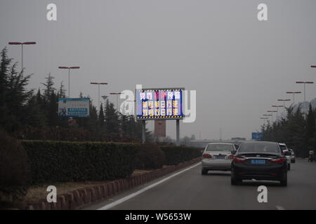 Di automobili che circolano su una strada di smog pesante di Taiyuan, città del nord della Cina nella provincia dello Shanxi, 26 febbraio 2019. Foto Stock