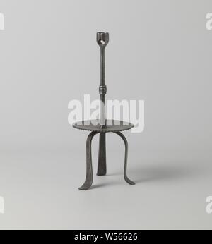 Candeliere di ferro su tre gambe, candelabro di ferro. Il round fat trap con bordo zigrinato è rivettata su tre lunghi e gambe piatte. Al di sopra di essa una lunga barra rotonda con un nodus in medio, finendo in portacandele, che è aperto su due lati., anonimo, West-Europa, 1500 - 1600, ferro (metallo), forgiatura, h 29.1 cm × d 13,0 cm Foto Stock