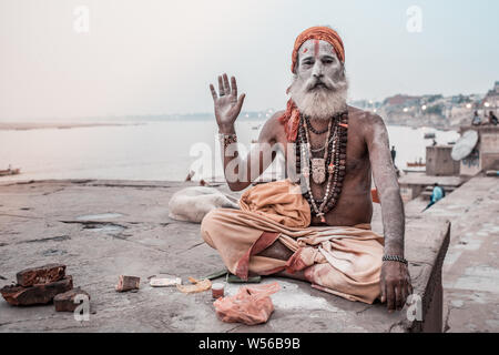 Un Sadhu seduto accanto al fiume Gange a Varanasi (India). Foto Stock