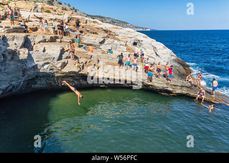 Thassos, Grecia - Luglio 20, 2019: i turisti stanno facendo immersioni in piscina naturale Giola in Thassos Island, Grecia Foto Stock