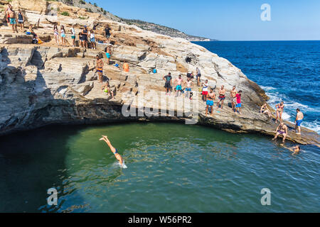 Thassos, Grecia - Luglio 20, 2019: i turisti stanno facendo immersioni in piscina naturale Giola in Thassos Island, Grecia Foto Stock