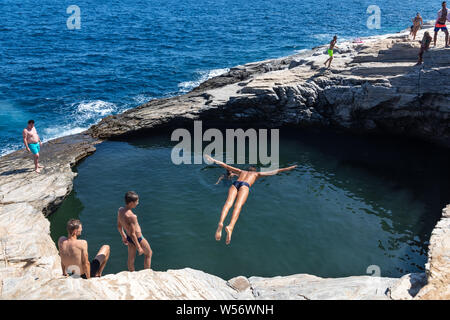 Thassos, Grecia - Luglio 20, 2019: i turisti stanno facendo immersioni in piscina naturale Giola in Thassos Island, Grecia Foto Stock