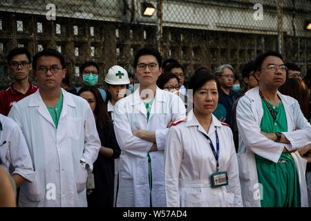 I partecipanti indossano il loro personale medico uniformi durante il rally.centinaia di lavoratori medici compresi i medici e gli infermieri hanno preso parte ad una manifestazione presso la Queen Elizabeth Hospital di Hong Kong per protestare contro il disegno di legge in materia di estradizione e a condannare la violenza da parte di bande di uomini in Yuen Long il 21 luglio. Foto Stock