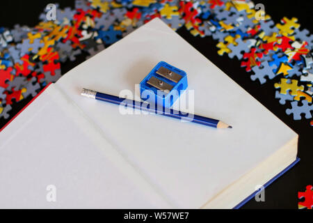 Libro bianco con matita e temperamatite. Foto Stock