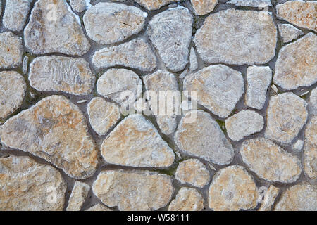 Grigio a muro di pietra con texture interessanti di pietre. Vintage sullo sfondo di un muro grigio. Foto Stock