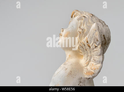 Statua di un angelo su sfondo grigio chiaro, design vintage. Spazio per il testo. Concetto di religione, convinzioni, di amore, di speranza e di lutto. Foto Stock