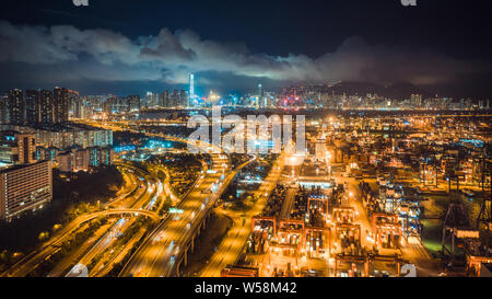 Porto di Hong Kong, il traffico autostradale e la Sinfonia di Luci mostra su edifici in città di notte. Asia turismo, destinazione di viaggio, business logistico Foto Stock