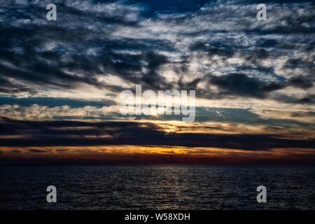 Cielo drammatico con nuvole al tramonto sul mare Adriatico vicino a Peschici città sul Gargano, Italia Foto Stock