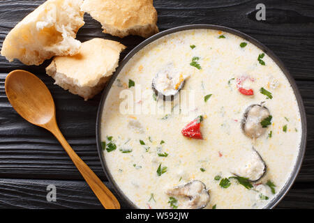 Deliziosa cremosa zuppa di pesce con anguille, formaggio e verdure close-up in una ciotola sul tavolo. parte superiore orizzontale vista da sopra Foto Stock