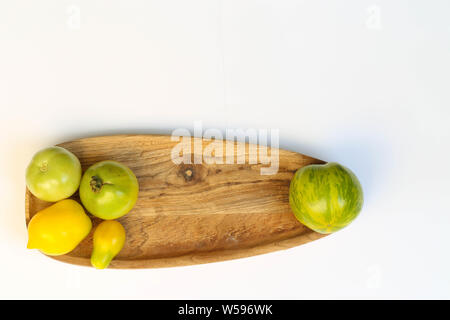 Grüne Tomaten auf Holzbrett Hintergrund Foto Stock