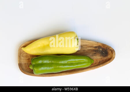 Grüner und gelber Paprika auf Holzbrett Foto Stock