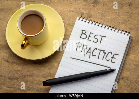 Best practice - la grafia in un notebook a spirale con una tazza di caffè Foto Stock