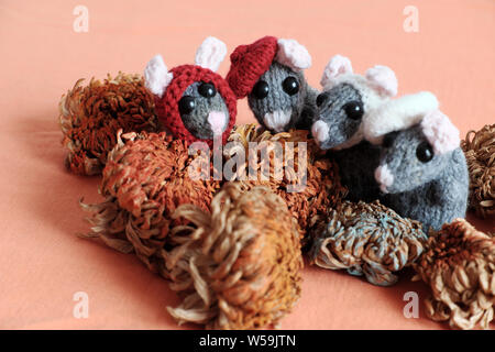 Gruppo topi cute stand su sfondo arancione, lana di piccole dimensioni di maglia di ratto da filati in tempo libero di artigianato Foto Stock