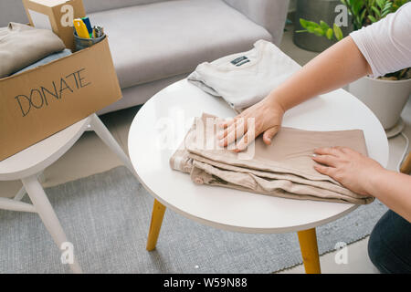 Donna preparare i vestiti vecchi vuole donare per la carità. Foto Stock