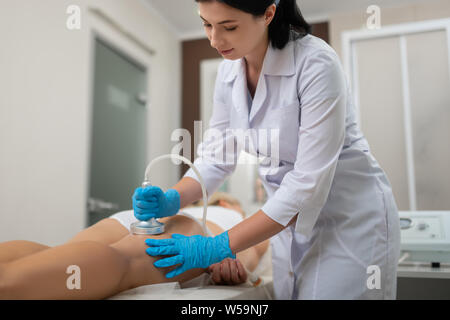 Bellezza medico facendo il suo client massaggio dell'anca. Foto Stock