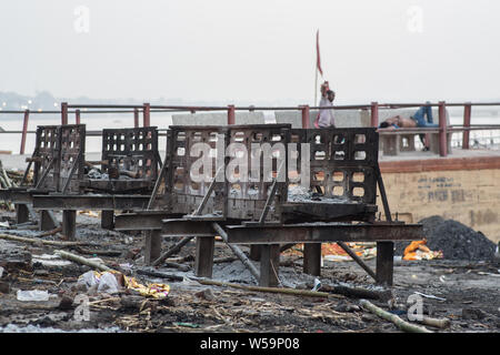 Un ardente ghat di Varanasi, India, dove si realizzano le cremazioni. Foto Stock
