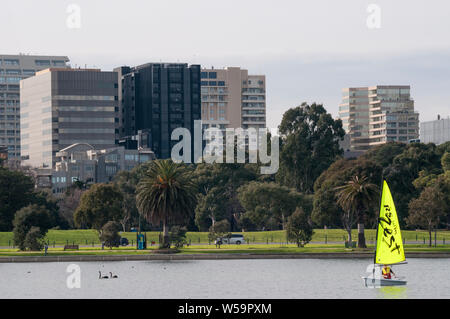 St Kilda Road uffici visto al di là di un marinaio solitario su Albert Park Lake, Melbourne, Australia Foto Stock