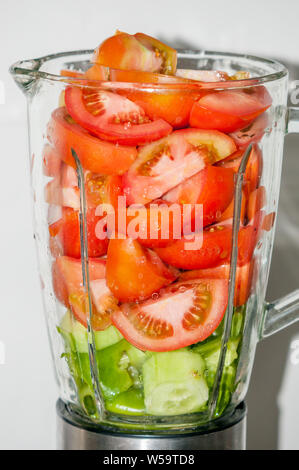 Ingredienti per fare il gazpacho in un robot da cucina, pomodoro, cetriolo e pepe verde. Proporzione reale di ciascun ingrediente Foto Stock