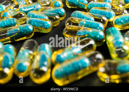 Le capsule di gelatina con il farmaco disperse dalla bottiglia sul tavolo. Foto Stock