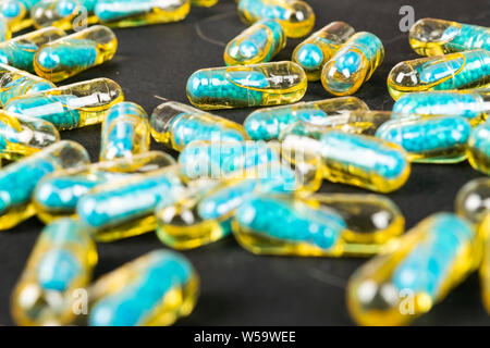 Le capsule di gelatina con il farmaco disperse dalla bottiglia sul tavolo. Foto Stock