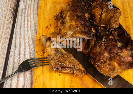 Costolette di maiale al forno con le spezie sul tagliere di legno. Foto Stock
