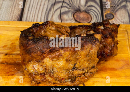 Costolette di maiale al forno con le spezie sul tagliere di legno. Foto Stock