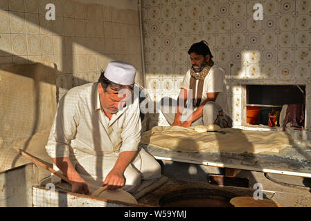 DOHA, Qatar - 6 febbraio 2016: due panettieri pakistano la produzione di pane in una panetteria tradizionale negozio in un quartiere popolare di Doha. Presa alla fine di una connessione Foto Stock