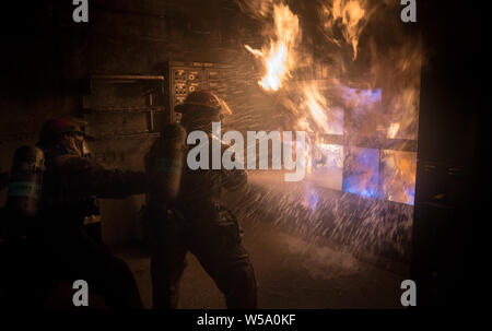 USS Carl Vinson marinai lotta una sala lavanderia incendio in una lotta antincendio training facility a Bremerton, Washington, 24 luglio 2019. (U.S. Foto di Marina di Massa lo specialista di comunicazione 2a classe Dylan M. Kinee/rilasciato) Foto Stock