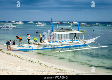 Turisti di ritorno da un viaggio in barca, Alona Beach, Bohol, Filippine Foto Stock