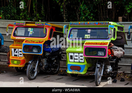 Una fila di coloratissimi tricicli, Alona Beach, Bohol, Filippine Foto Stock