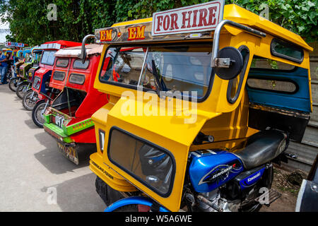 Una fila di coloratissimi tricicli, Alona Beach, Bohol, Filippine Foto Stock