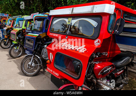 Una fila di coloratissimi tricicli, Alona Beach, Bohol, Filippine Foto Stock