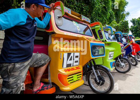 Una fila di coloratissimi tricicli, Alona Beach, Bohol, Filippine Foto Stock