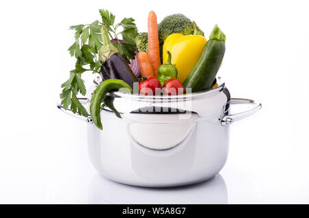 Verdure miste e gli ingredienti nella pentola a pressione sullo sfondo bianco Foto Stock