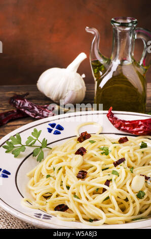 Ancora vita.primo piano di una piastra con gli spaghetti cotti con olio d'oliva, aglio e peperoncino, tradizionale ricetta italiana Foto Stock