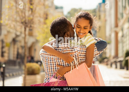 Positivo il piacere di adolescente abbracciando la sua giovane papà Foto Stock