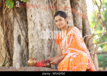 Donna adorare un albero sacro Foto Stock